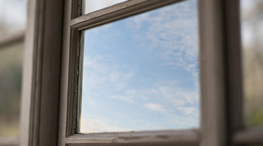 A window with the sky clearly reflected in the glass, which is what the bird sees